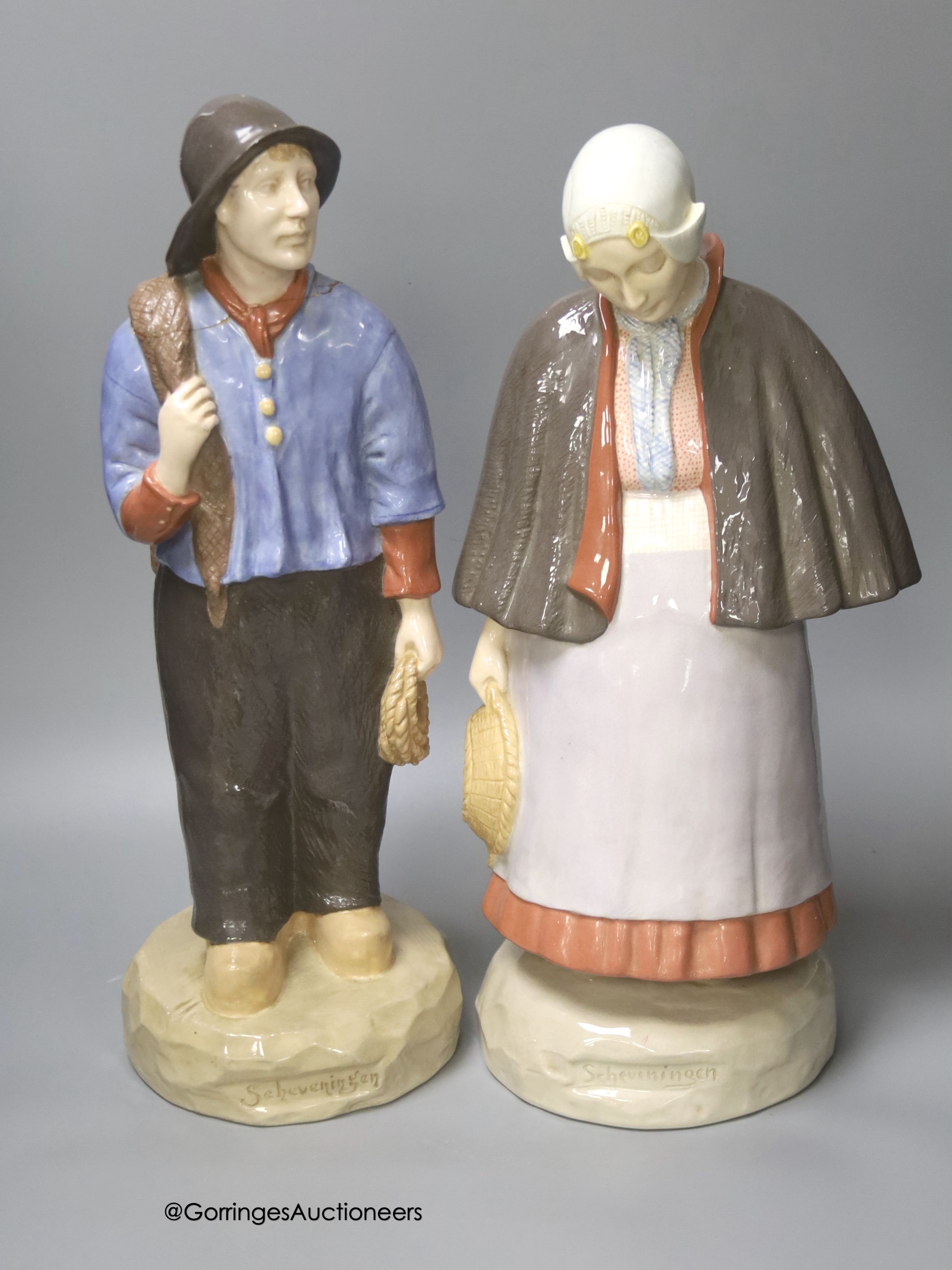 A pair of large Gouda pottery figures of a fisherman and fisherwoman, inscribed 'Scheveningen', 41cm